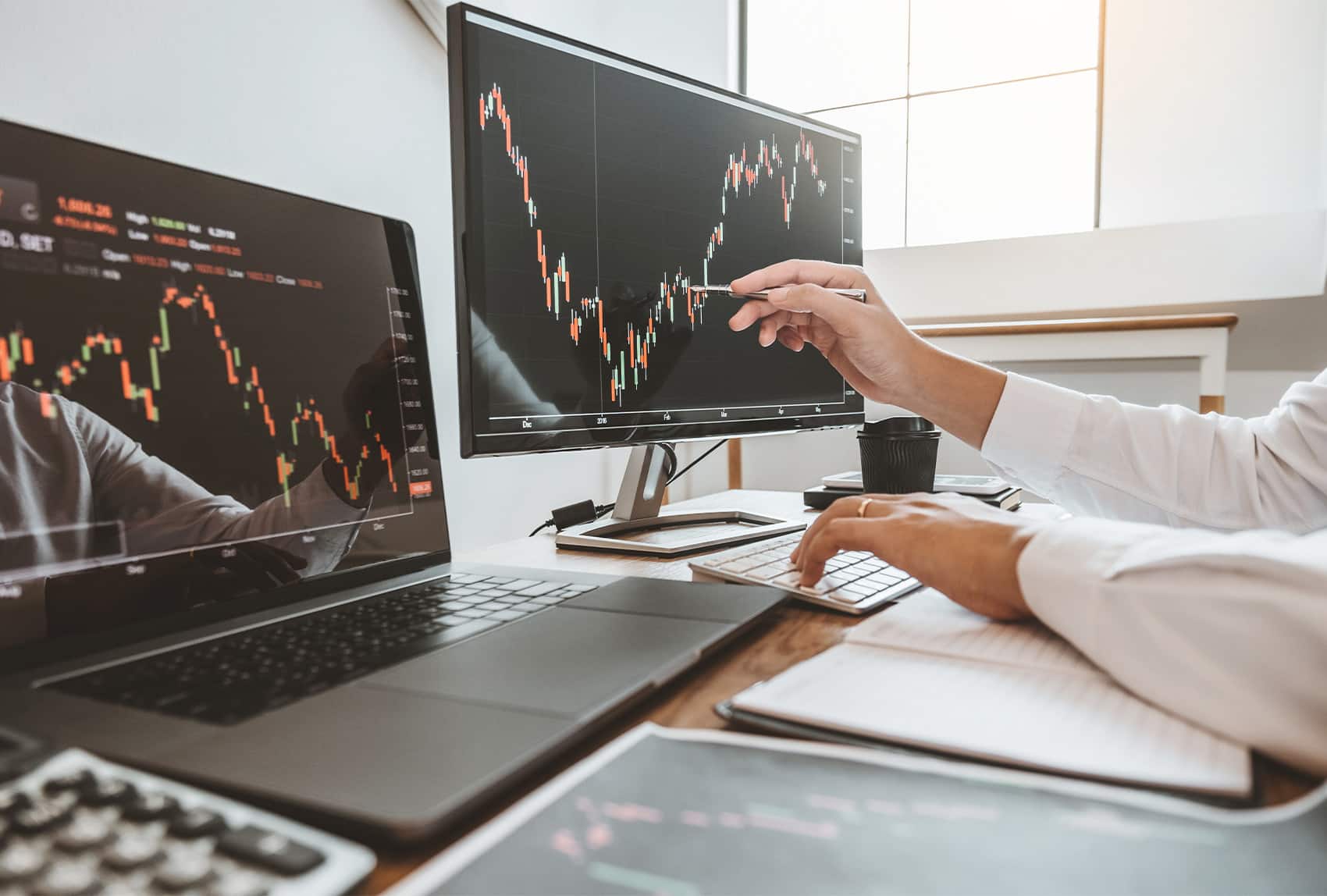 pointing at a screen trading commodities